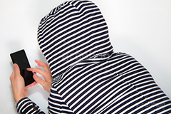 スマホをいじる猫背の怪しい男,猫背,怪しい,不審,スマホ,スマートフォン,デジタル,連絡,いじる,操作,指,タップ,フリック,男性,モデル,男,青年,手,イメージ,人物,ボーダー,フード,パーカー,クレーム,クレーマー,苦情,誹謗,中傷,tap,finger,hand,image,smartphone,phone,digital,model